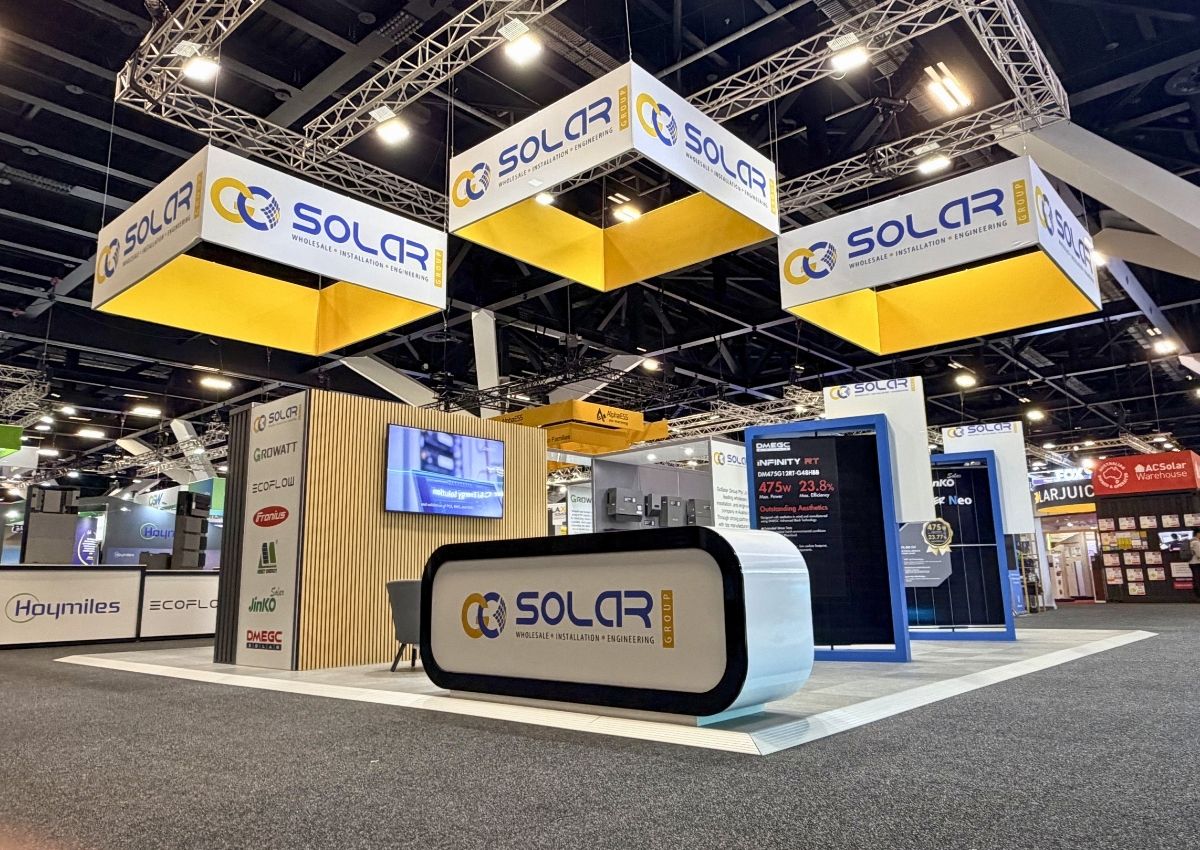 An image showing a finished build island type exhibition stand with overhead branded banners and open conversation areas