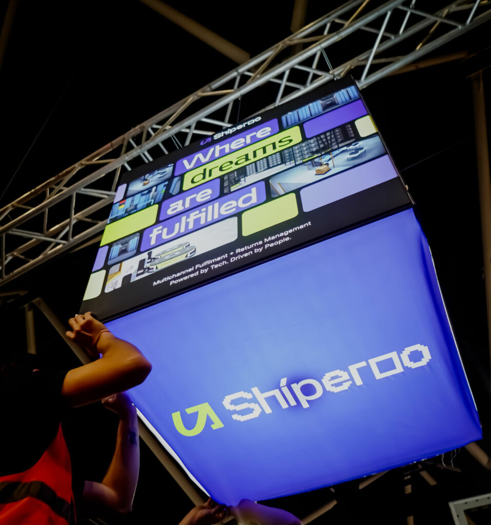 Team installing overhead branded signage cube