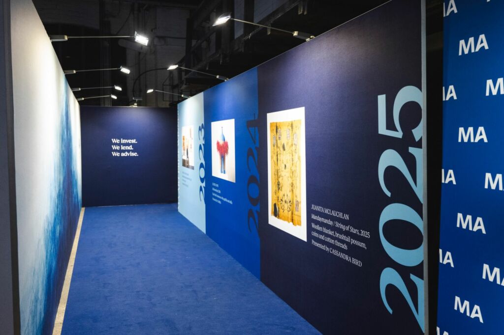 Large-format tensioned banners and blockout fabric walls provided texture, branding, and wayfinding