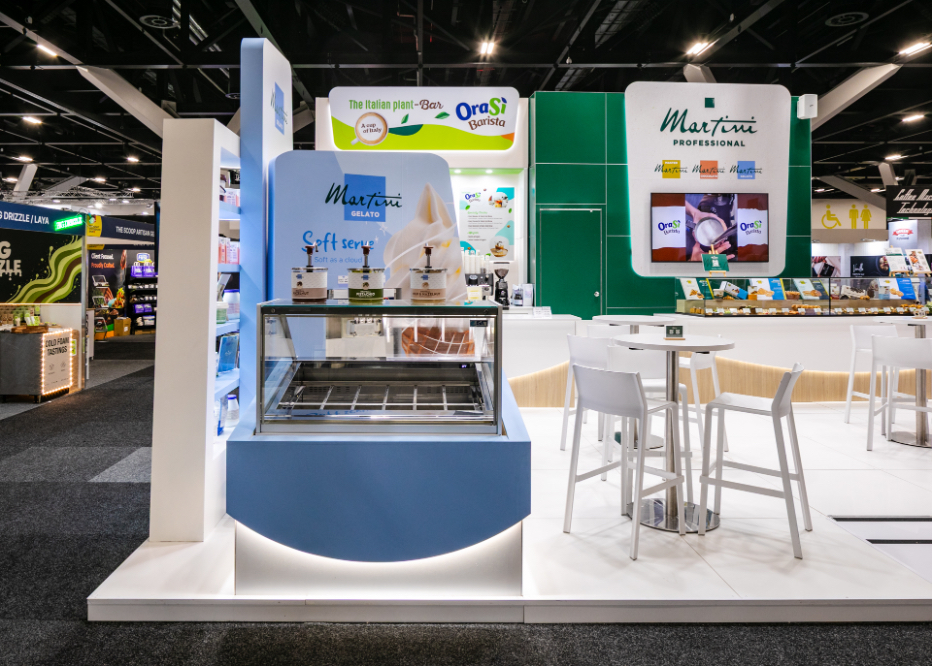 Bespoke double-sided freestanding product display shelving unit with integrated lighting, warm-tone shelf finishes, and gold accent base built for Master Martini at Restaurant & Foodservice Show Australia 2026